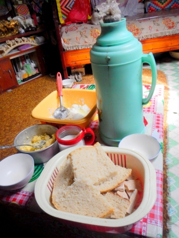 A typical meal in northern Mongolia-- hearty bread, yak cheese, yak butter, sugar (for the bread), and well-salted tea