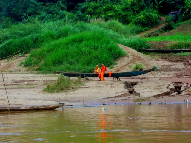 Monks on the riverbank. Taking the riverboat from Laos back to Thailand