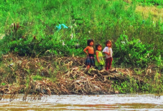 Children on the bank. Taking the riverboat from Laos back to Thailand