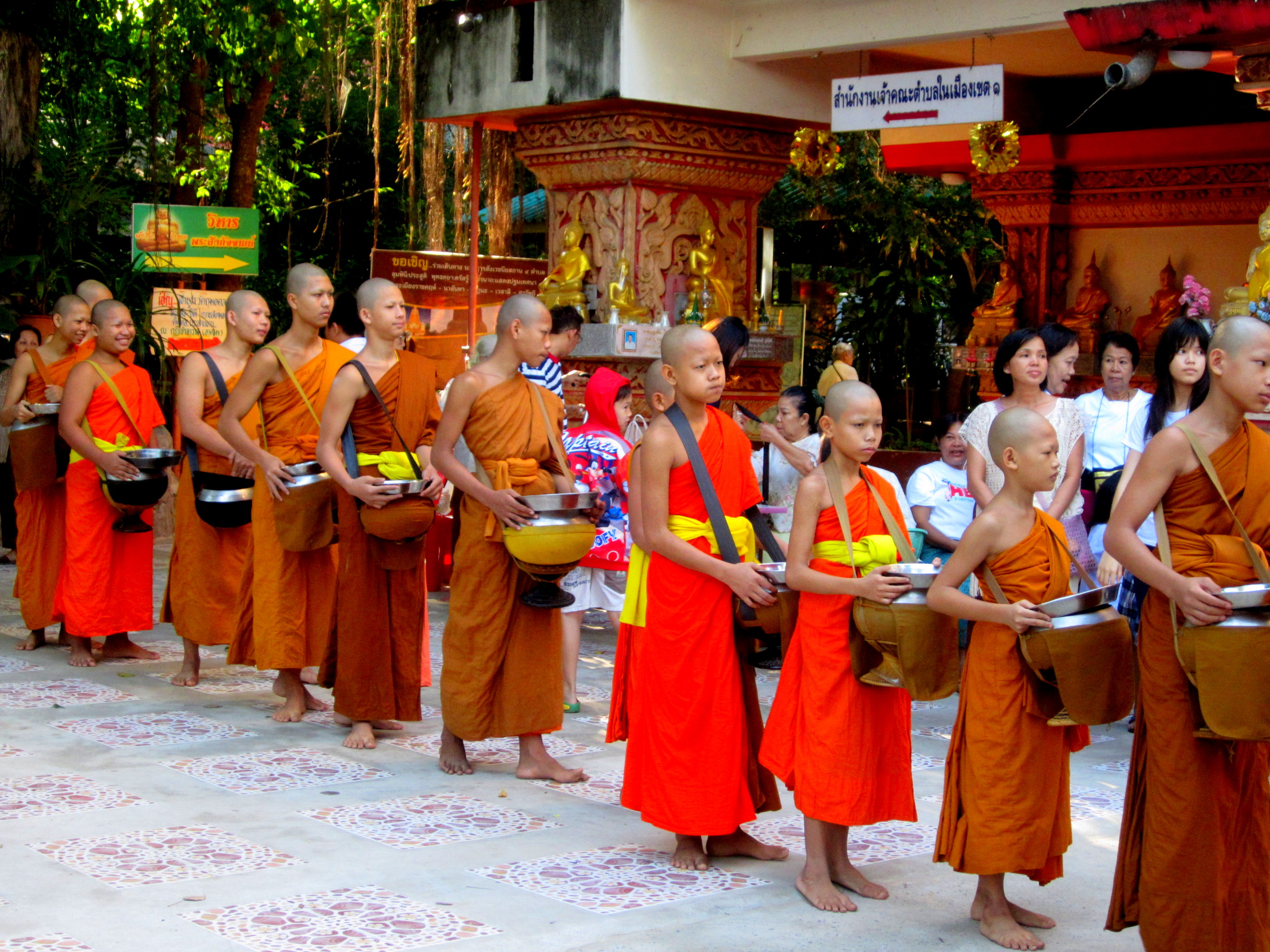 Monks collecting offerings at the Buddhist monastery in Khon Kaen, Thailand